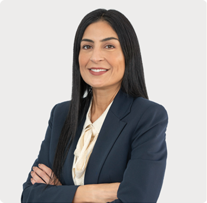 A woman in a suit and tie with her arms crossed.